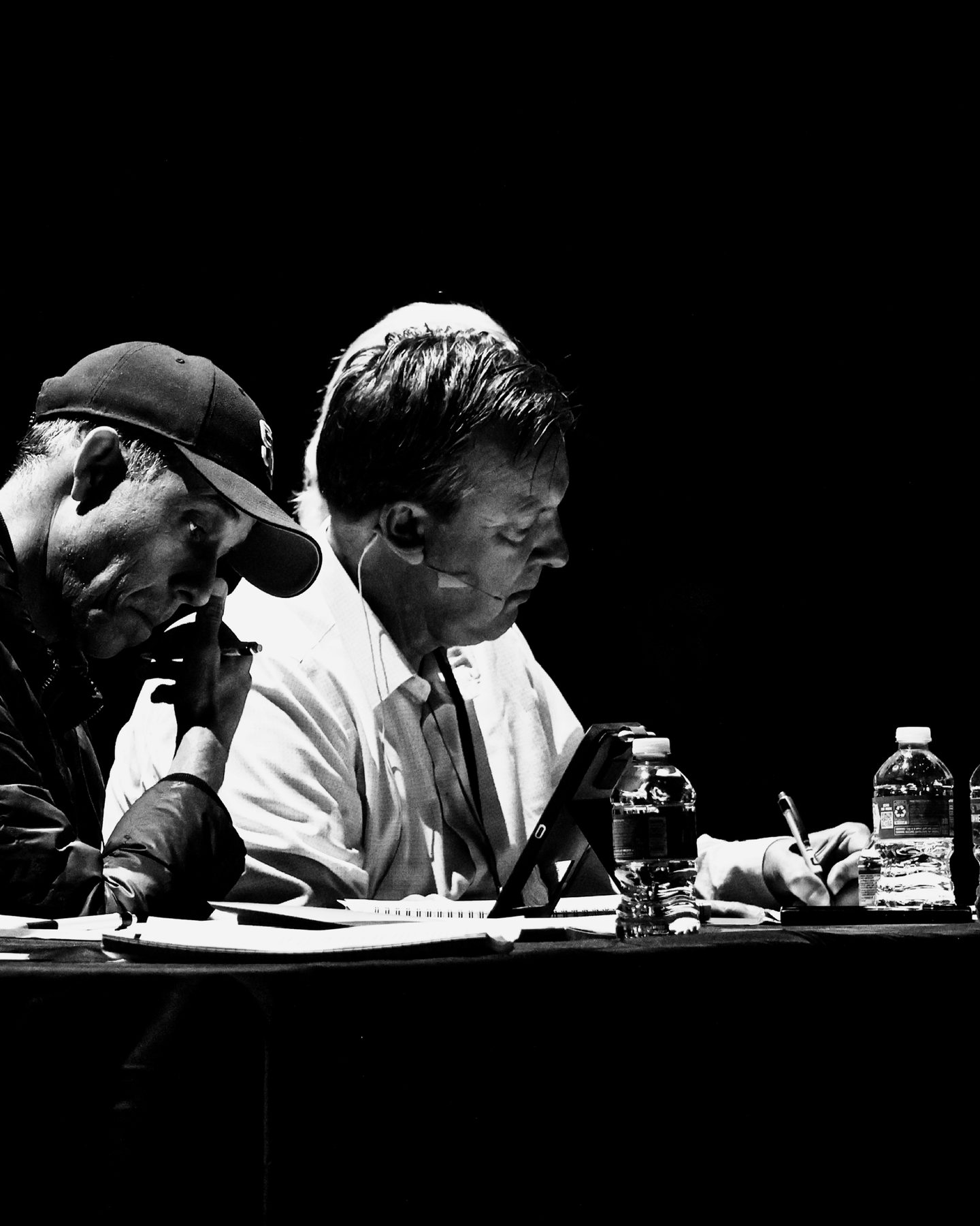 Two professionals taking notes while they evaluate a pitch.