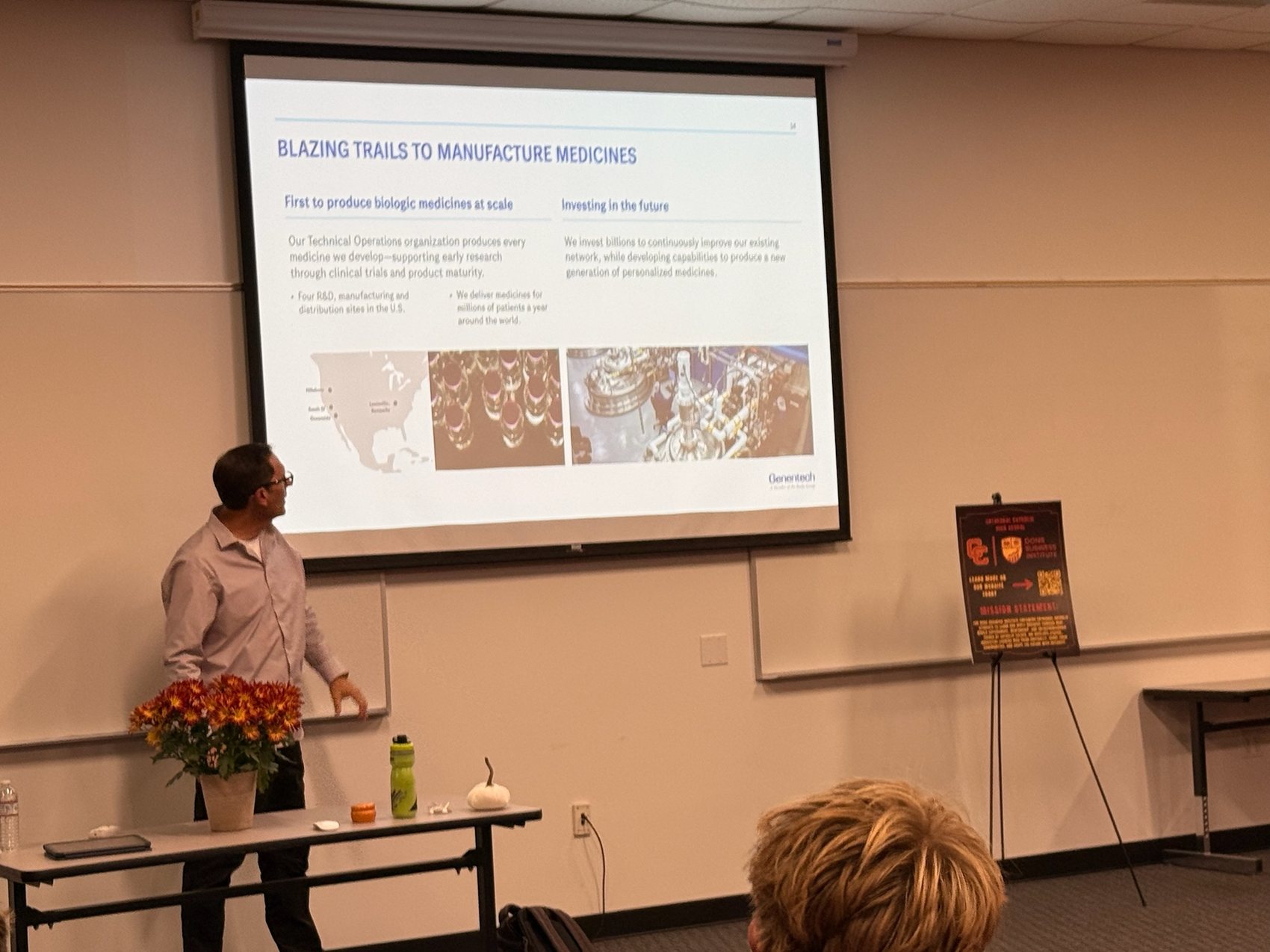 Chris LeTourneau of Genentech pointing to a manufacturing slide titled Blazing Trails to Manufacture Medicines.