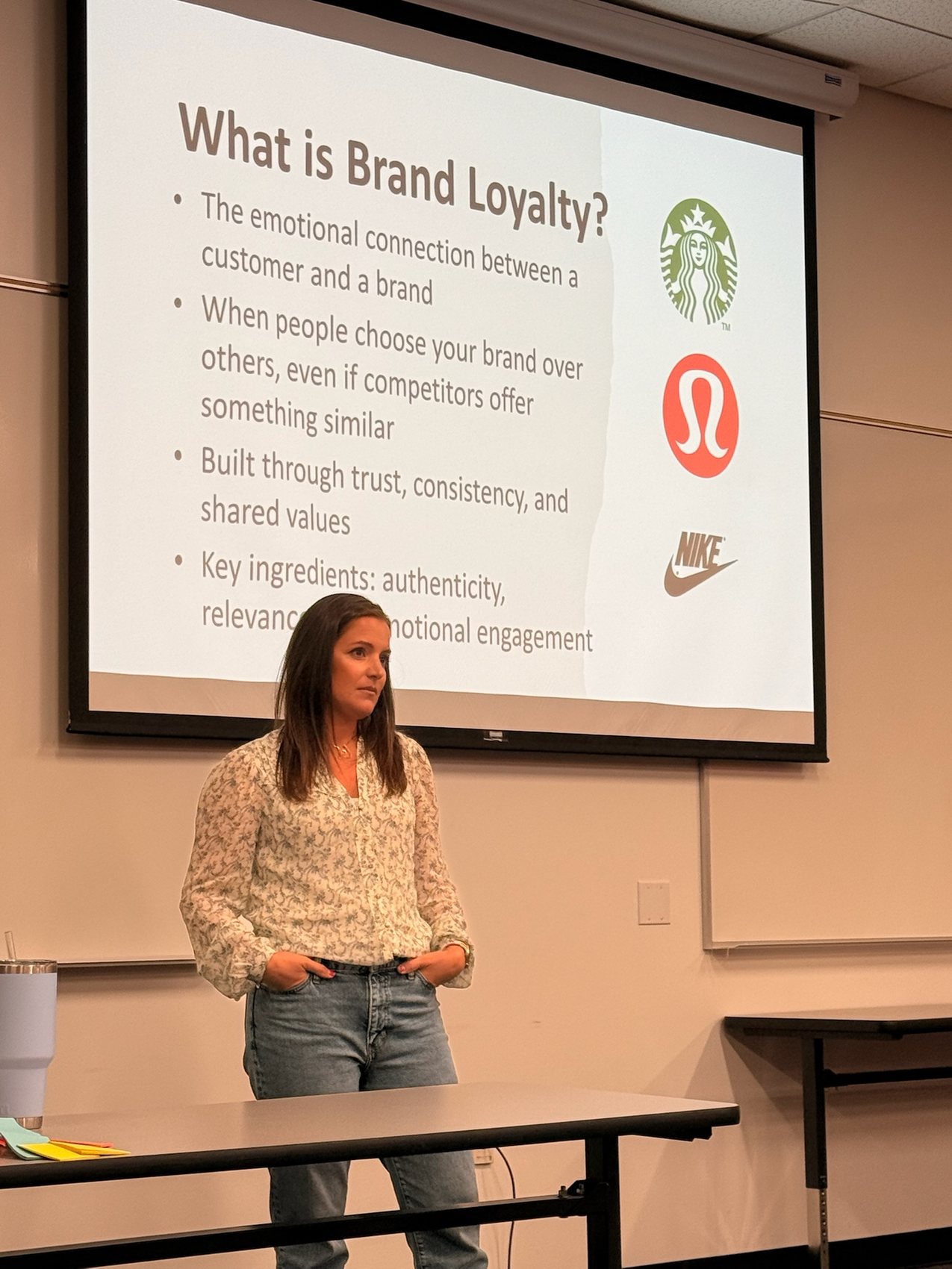 Krista Moffett presenting a slide asking What is Brand Loyalty, with Starbucks, Lululemon and Nike logos.