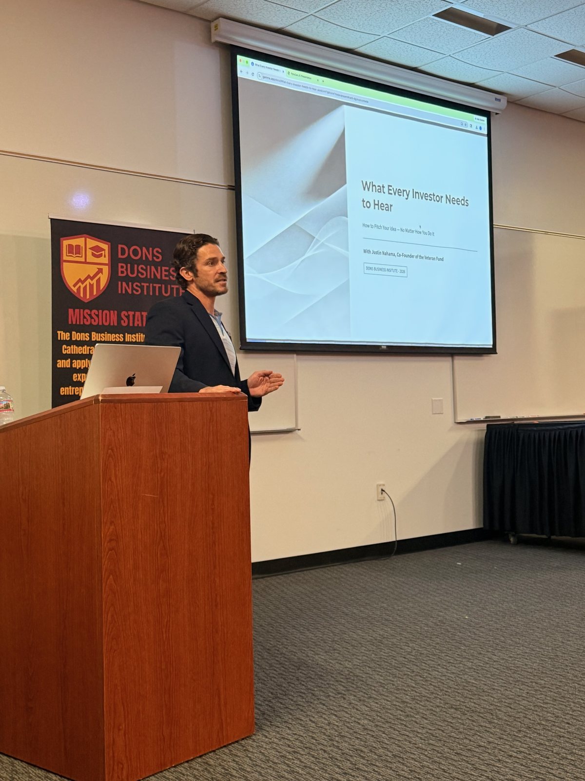 A student presenting from the podium during a DBI session.