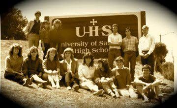 A group of students in the 1980s posing in front of the University of San Diego High School sign.